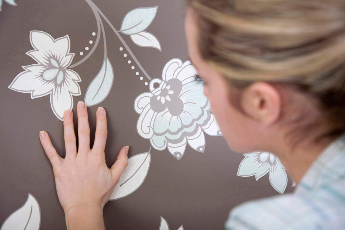 Woman checking wallpapers texture Wallpaper Carpets Distributors